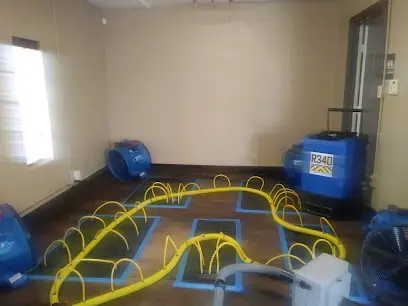 Floor drying mats and air movers set on a wet floor in Weatherford