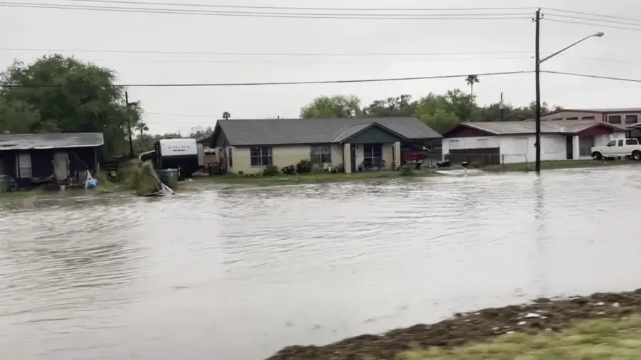 Storm water covering a street in front of houses after heavy rain in North Texas